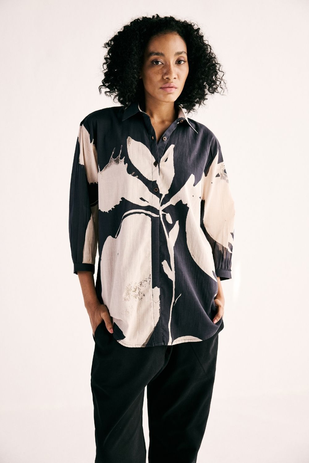 Black Luna Iris shirt by Khara Kapas featuring a monochromatic floral print, button-down front, long sleeves and a relaxed fit in breathable cotton mul.